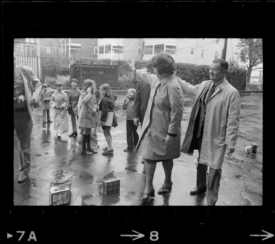 Louise Day Hicks waves to children at the school where she is going to vote during her primary election for mayor