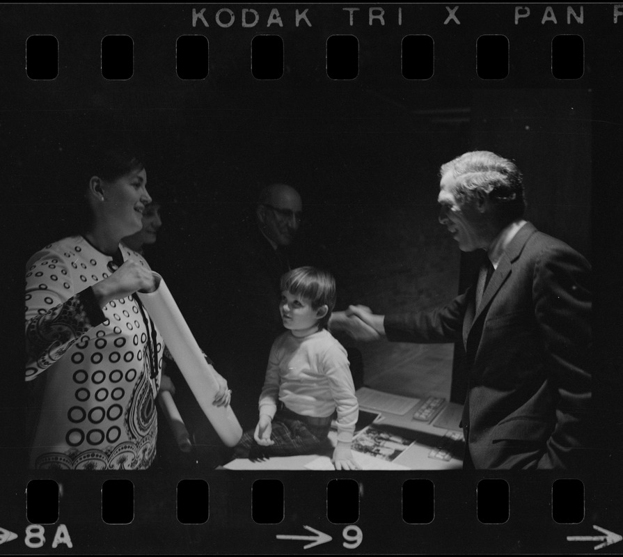 Mayor Kevin White greets families of POW's while they hang a poster in Boston City Hall to bring awareness of the plight of GIs being held prisoners by North Vietnam