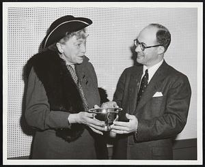 For Release: Thursday, April 28. From: The Greater Boston Chamber of Commerce -- Estelle Furey, Director of Publicity. John Adam Jr., director of the Greater Boston Chamber of Commerce and vice president, Central Mutual Ins. Co., appoints Marjorie Mills Chamber courier to present a Paul Revere Bowl and Paul Revere Hat to the American Women in Radio and Television at their national convention being held in Chicago May 5-8. The inscription reads: Presented by the Greater Boston Chamber of Commerce to the American Women in Radio and Television in recognition of their outstanding work in the field of American Broadcasting.” With these gifts goes an invitation from the Chamber to AWRT members to attend next year’s national convention which will be held in Boston April 1956.