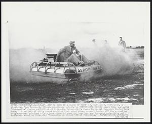 Off He Goes in a Cloud of Dust-- Dr. William H. Bertelson, a physician from Neponset, Ill., demonstrates vehicle he constructed in his spare time and calls "Aeromobile" during exhibition at Princeton University's James Forrestal Research Center here today. A variety of oddly shaped vehicles that scoot along several inches off the ground on self-produced cushions of air were shown as some 200 American and European scientists and engineers wound up three-day "Symposium of Ground Effect Phenomena."