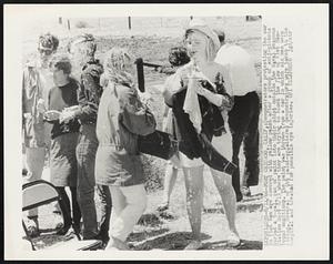 Demonstrators protesting the war in Vietnam are covered with yellow paint after a group of anti-pickets hurled a 5-gal. can of paint into their midst outside the Naval Weapons Station here 8/13 where they are trying to block the flow of Vietnam-bound munitions. The paint was thrown from a car in which six men were riding. Several of the paint-splattered demonstrators were taken to the hospital and treated for possible eye injuries.