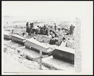 Earthquake Aftermath--Laborers dig graves on a slope outside the earthquake ravaged city of Skopje in Yugoslavia as bodies of the quake's victims in crude coffins await burial. Hundreds died in last Friday's earth upheaval, the nation's worst natural disaster.