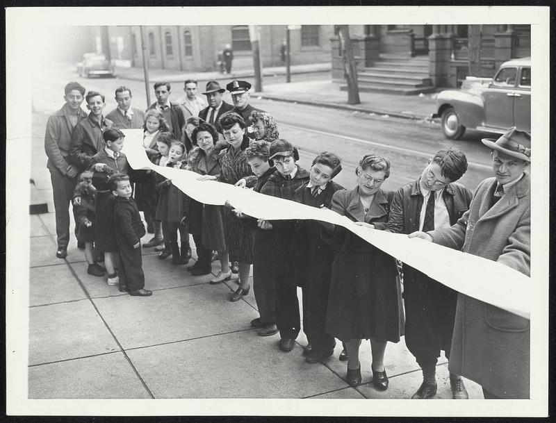 Letter for a Soldier. This is part of the 300-foot letter written by Michael Jaffe and 30 other persons in his neighborhood to Private Herman Kaufman of the Air Crew Officers' Training School, located at North Carolina State College, Raleigh, N.C. Neighbors are getting a last look at it before it is mailed.