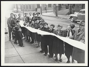 Letter for a Soldier. This is part of the 300-foot letter written by Michael Jaffe and 30 other persons in his neighborhood to Private Herman Kaufman of the Air Crew Officers' Training School, located at North Carolina State College, Raleigh, N.C. Neighbors are getting a last look at it before it is mailed.