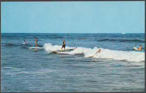 Men surfing, swimmers in background