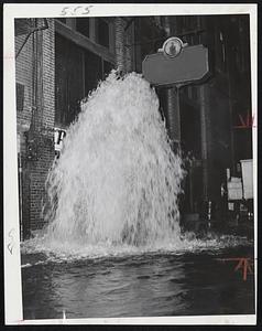 Geysers from broken fire hydrant spurts 15 feet in air, flooding part of Providence St., Back Bay, early today. Water gushed for some 20 minutes after milk truck driven by Nikolas Kiladis, 254 Willis Ave., South Medford, backed into hydrant while making delivery.