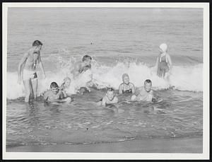 Plum Island - Campers frolic in surf as counselors William Taplin (left) + Daniel Harrington Jr. (3rd from left) keep a watchful eye.