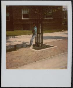 Boy leaning against a tree