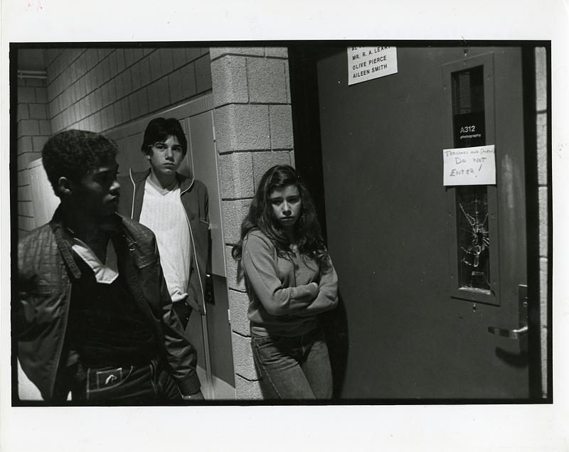 Three students standing outside photography room