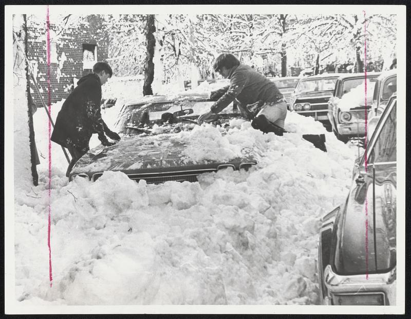 South Street, Jamaica Plain, looked like a winter wonderland in more ways than one yesterday. Two young people had to clamber atop this car just to begin to dig it out, and there was no telling how long the snow in front of the car would stay there.