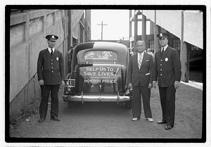 Police officers standing in front of a police car