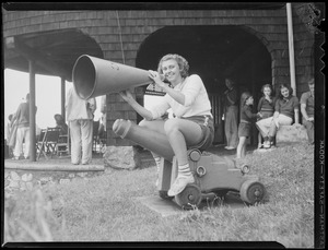 Woman with bullhorn astride starting cannon