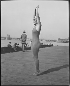 Girl stretches to full length for swim competition, Charles River