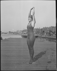 Girl stretches to full length for swim competition, Charles River