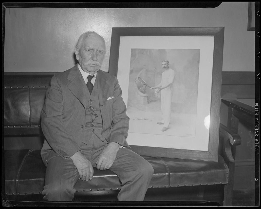 Thomas Pettitt, tennis great, sits with photo of himself in his prime