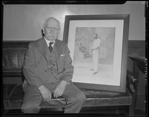 Thomas Pettitt, tennis great, sits with photo of himself in his prime
