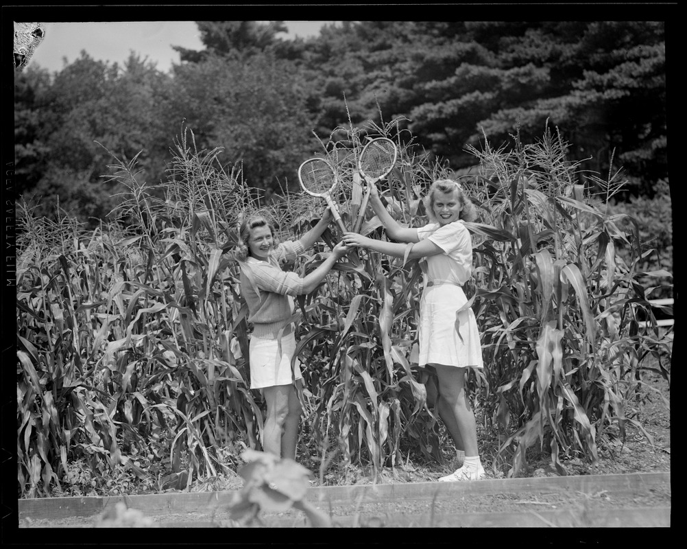 Two girls next to corn field, Essex Tennis