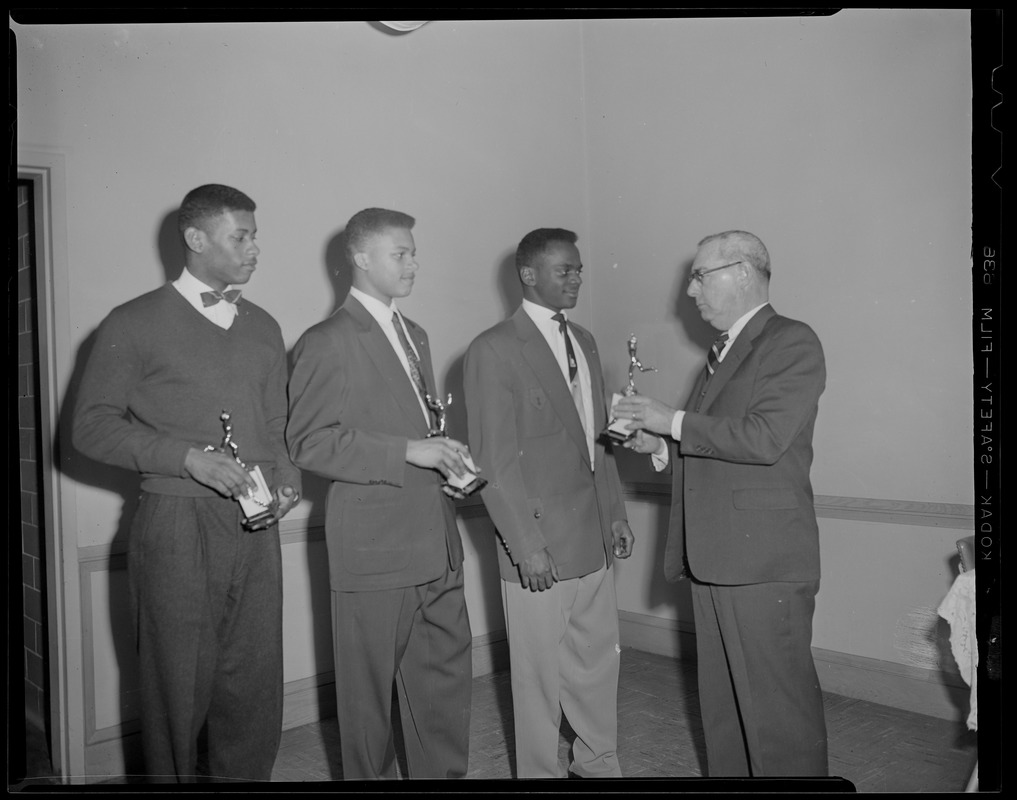 Three black athletes with trophies