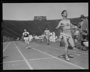 Runner crosses finish line, Harvard Stadium