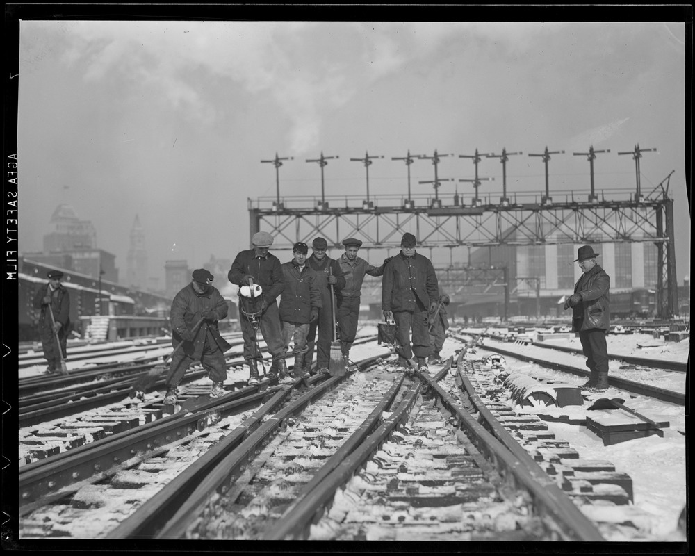 Workers clearing South Station tracks of snow and ice