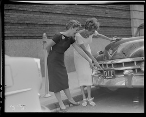 Two pretty Herald-Traveler girls find an odd registration number plate (DIE) on Avery St., Boston