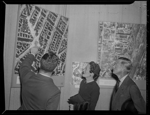 The Duke and Duchess of Windsor examine aerial photos of bomb damage to German cities, while in Boston
