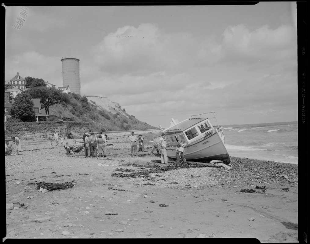 Boat ashore on Winthrop Beach. Water tower on Cottage Hill in background. Yirrell Beach now, water tower in back, 'Greathead' (Cottage Hill) old Green Hill.