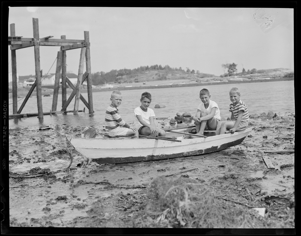 Boys sit in boat amid debris from hurricane