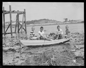 Boys sit in boat amid debris from hurricane