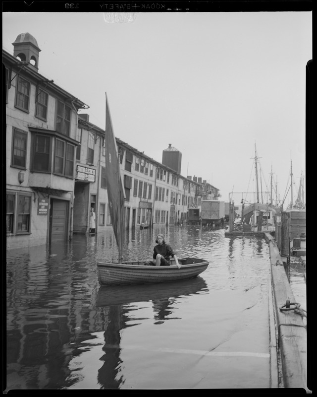 Woman in sailboat at flooded T-wharf