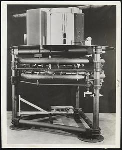 Clam Shell furnace is one of the hottest things ever built for industry or research. Developed by the Air Force-Cambridge Research Laboratory and Arthur D. Little, Inc., it has an arc electrode housed in the top. Two reflecting mirrors (center) focus radiant heat of 6,700 degrees Fahrenheit onto specimens holders placed at the bottom.