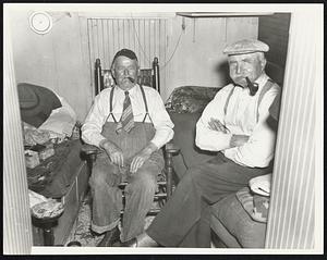 House boats. K. St. Boat Yard - South Boston. Peter Legere, 79 years old. Thomas Olsen, 76 years old having a chat aboard house boat tied up in the small canal that borders the yard.