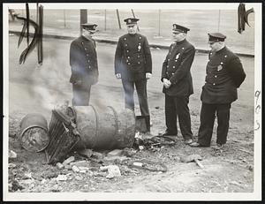 The Boston policemen, helping Everett police maintain order in the waterfront labor dispute, kept warm today around this burning barrel of rubbish. The policemen (left to right) are: Leslie Bickford, station 3; Hugh Mooney, station 11; Walter R. Russell, station 6, and John Campbell, station 7.