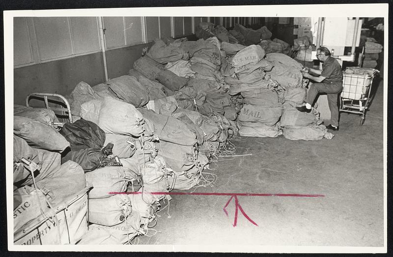 Not Going Through, as tradition has it, are these bags of mail in the South Postal Annex, part of the tons held up by strike in New York and New Jersey. Postal worker Anthony Sersanti makes certain only embargoed mail is in pile.