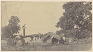 Ruined brick stupa at Basarh, with lion pillar on the left