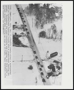 Cleveland, Ohio - Traffic crawls along a snow covered road in southeastern Cuyahoga County with a snowscraper leading the parade. Throughout the area residents are digging out from under a 20-inch snowfall with drifts as high as 20 feet. Many district roads were blocked.