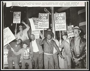 Detroit: General Motors workers wave picket signs outside a Detroit GM plant after the United Auto Workers struck giant General Motors at midnight. Labor Strike.