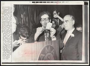 This Critic Is Really Burned Up--New York psychiatrist Dr. Richard Kunnes burns his American Medical Association membership card at opening session of the organization's annual meeting at New York's Americana Hotel Sunday. At right is A.M.A. speaker of House of Delegates, Dr. Russel Roth of Erie, Pa., who gave way at the podium to Dr. Kunnes, who then sharply criticized the A.M.A. for allegedly opposing progressive health legislation. The card-burning followed.
