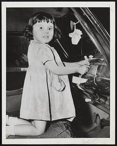 Little Locksmith is Barbara Zeldin, 4, of Philadelphia, who demonstrates her lock-picking technique on the glove compartment of her father's car. Her father taught her how to use tools for opening simple locks when she became interested eight months ago. Her brother, Burton, 10, also can open locks, an occupation which his father, a key-maker, practices in emergencies.