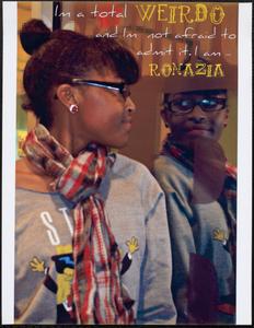 Girl in glasses and plaid scarf looking in a mirror