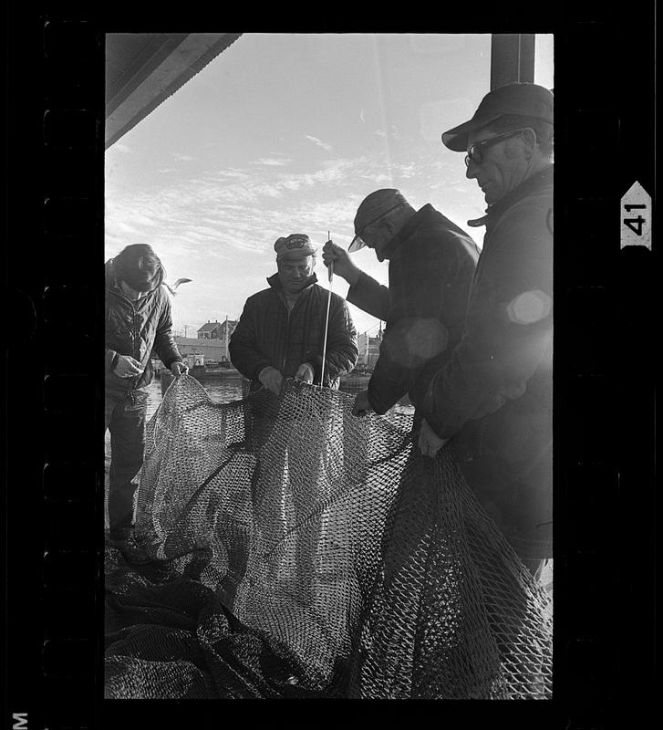 Fishermen mend nets, Gloucester