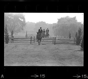 Equestrians leap fence, Milton