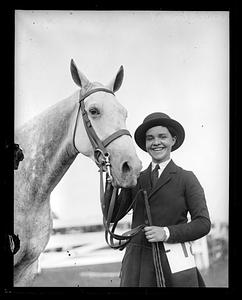Unidentified woman holding the reins of a horse