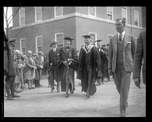 Two unidentified people wearing cap and gown