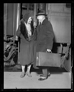 A man and a woman laughing by a train