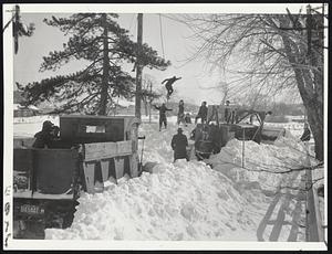 Typical Greater Boston Scene--Snowplows were marooned in huge drifts. This shot was snapped on Palmer street, Quincy. Note the boy jumping from an electric light pole into the snow bank. The boys thought is was great fun to see their street snowed under.