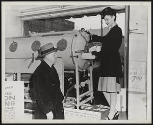 Latest Iron Lung is demonstrated by Miss Patty Chamberlin to Mayor Raymond Casey of Revere. Six lungs of this type will be donated to local hospitals from the proceeds of the President's Ball. 29, at Boston Garden.