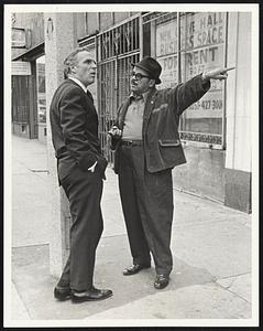 Mayor White leans against a lamppost in the Grove Hall section of Roxbury while he listens to the complaints of George Munoz of Roxbury on the campaign trail yesterday.