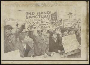 [illegible] Demonstrators-- On their march through New York City today, [illegible] demonstrators passed these counter demonstrators. One carries sign urging bombing of Hanoi, North Vietnam. Another holds up sign urging support of GIs, and youth in center waves American flag.