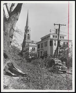 In Old Newport, R. I., telephone workers restore service on street tangled with fallen trees.